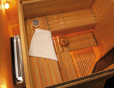Harvia 12kW Concealed Sauna Heater - installed behind the wall, vent grille visible inside the sauna